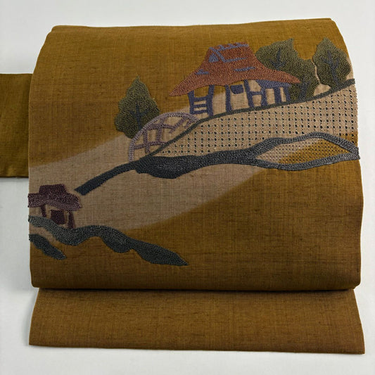 【美品】名古屋帶 秀品級 紬織織 建物 樹木 相良刺繡 茶 純蠶絲