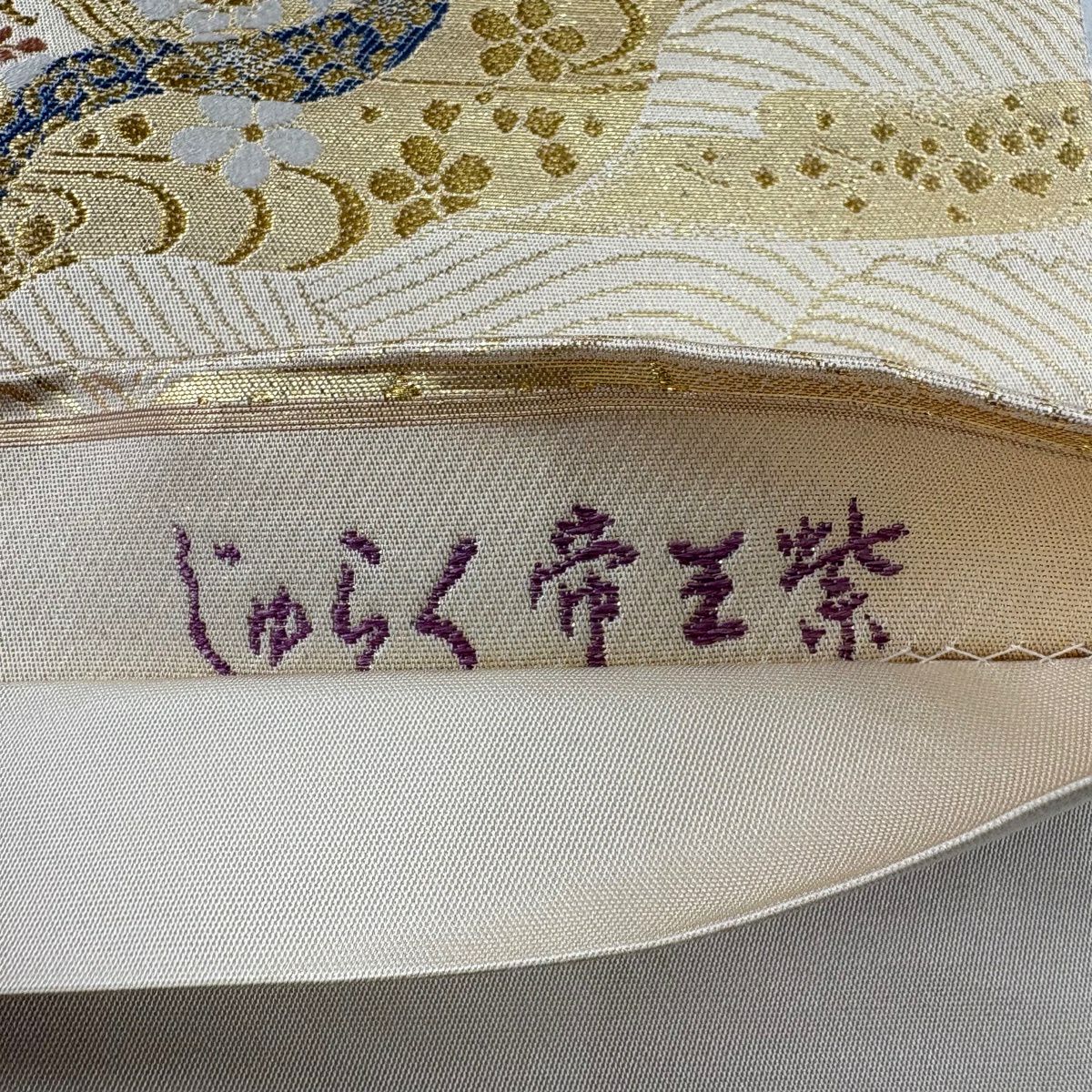 【美品】 袋帶 名品級 じゅらく 落款あり 帝王紫 草花紋 波 金金箔 刺繡 米色 お太鼓柄 純蠶絲
